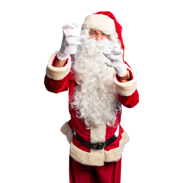 Moyen-âge bel homme portant le costume du Père Noël et la barbe debout criant frustré par la rage, les mains essayant d'étrangler, hurlant fou
 - Photo, image