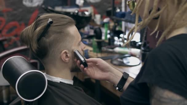 Young handsome bearded man at barbershop, shallow depth of field - Felvétel, videó