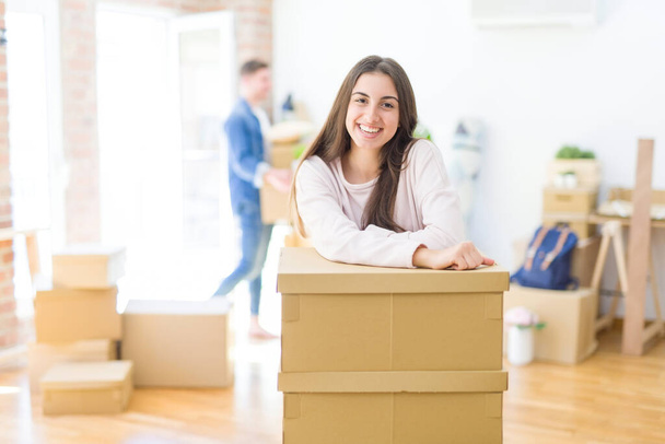 Beautiful young couple moving to a new home, young woman smiling - Photo, Image