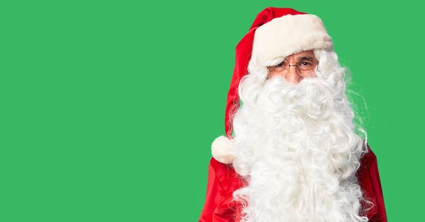 Medioevo bell'uomo che indossa il costume di Babbo Natale e la barba in piedi lingua sporgente felice con espressione divertente. Concetto di emozione
. - Foto, immagini