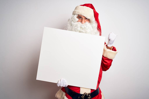 Keski-ikäinen mies yllään Joulupukin puku tilalla banneri yli eristetty valkoinen tausta osoittaa ja osoittaa peukalolla sivulle iloinen kasvot hymyillen
 - Valokuva, kuva