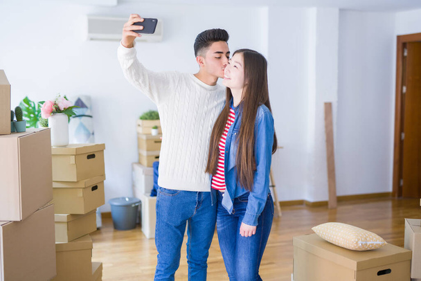 Jonge Aziatische paar glimlachend het nemen van een selfie foto met smartphone, verhuizen naar een nieuw huis samen - Foto, afbeelding