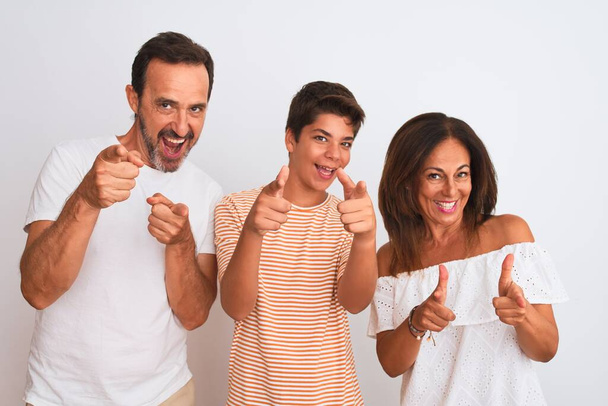 Háromtagú család, anya, apa és fia fehér, elszigetelt háttér fölött állnak, ujjal mutogatva a kamerára boldog és vicces arccal. Jó energia és rezgések. - Fotó, kép