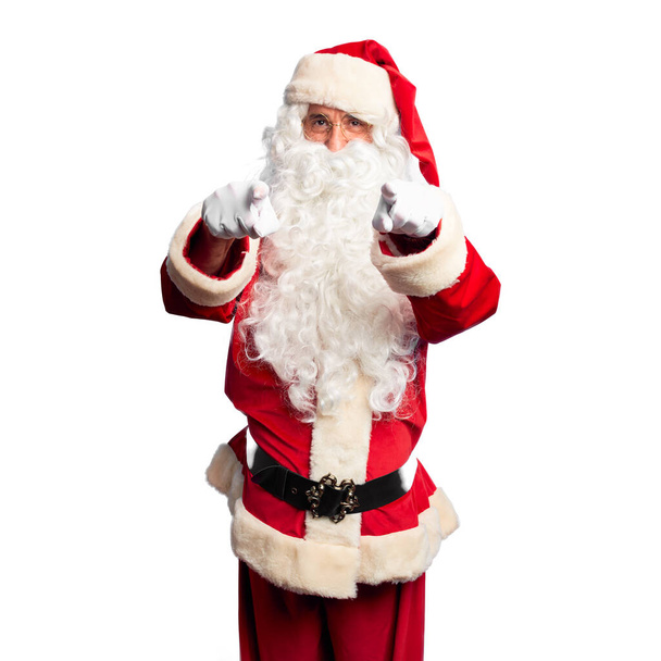 Красивый мужчина средних лет в костюме Санта-Клауса и с бородой, указывая на тебя и камеру пальцами, улыбаясь позитивно и весело
 - Фото, изображение