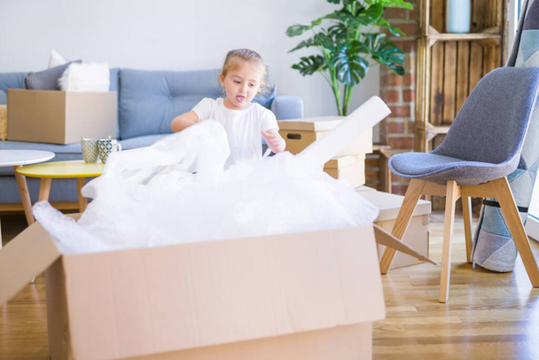Menina criança bonita brincando com caixas em nova casa
 - Foto, Imagem