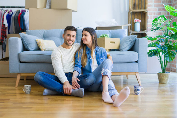 Young beautiful couple sitting on the floor of new apartment, sm - Foto, imagen