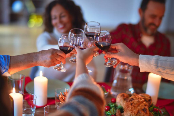 Bela família sorrindo feliz e confiante. Comer peru assado e brindar com xícara de vinho celebrando o Dia de Ação de Graças em casa
 - Foto, Imagem