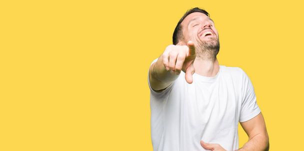 Pohledný muž nosí ležérní bílé tričko rajským vás, ukazující na fotoaparát s prsty rukou přes hrudník, Škoda výraz - Fotografie, Obrázek