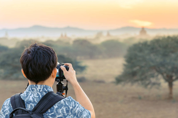 Η πίσω όψη των τουριστών θαυμάζετε και παίρνετε φωτογραφίες ενώ ο ήλιος δύει στους αρχαίους ναούς της παγόδα στην ασιατική ιστορική κληρονομιά Bagan, Μυανμάρ - Φωτογραφία, εικόνα