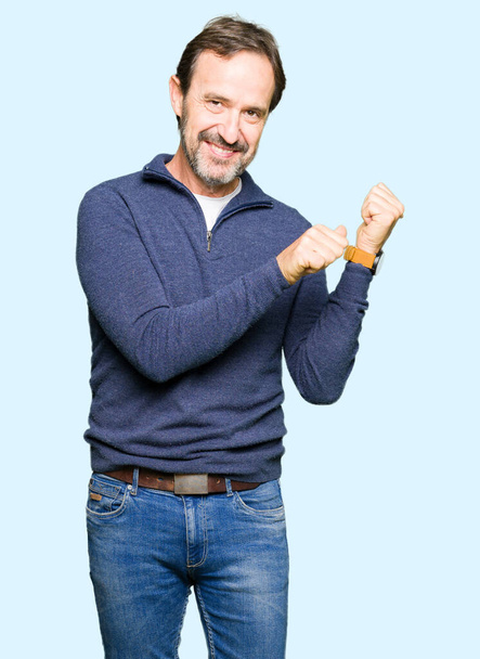 Orta yaş yakışıklı adam bir kazak giyen el ve başparmak yukarı arka işaret, kendinden emin gülümseyerek - Fotoğraf, Görsel