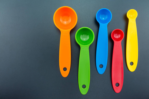 a set of measuring spoon of plastic on black background. - Photo, Image