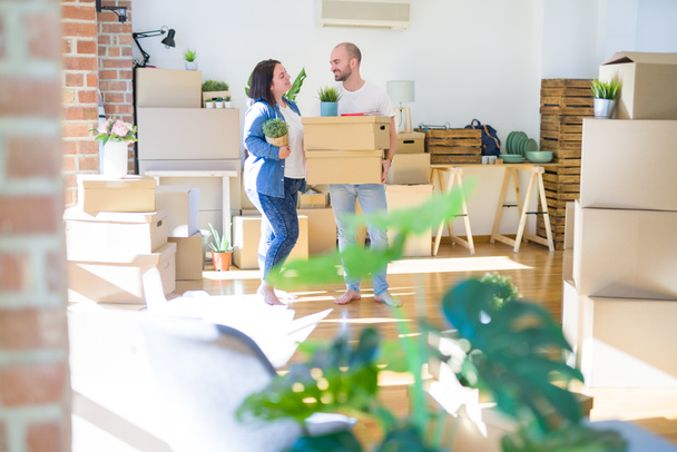 Fiatal pár költözik egy új otthon, mosolyogva boldog gazdaság kartondobozok - Fotó, kép