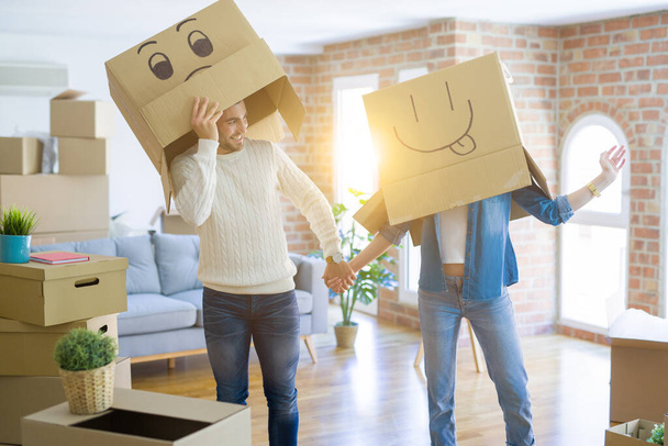 Αστείο ζευγάρι φορώντας χαρτοκιβώτια με διασκεδαστικά τρελά πρόσωπα emoji  - Φωτογραφία, εικόνα