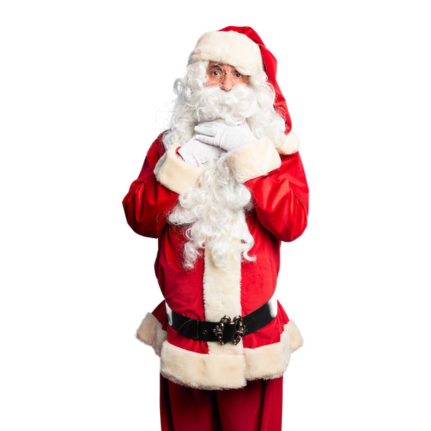 Middle age handsome man wearing Santa Claus costume and beard standing shouting suffocate because painful strangle. Health problem. Asphyxiate and suicide concept. - Photo, Image