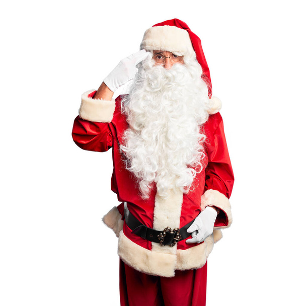 Middle age handsome man wearing Santa Claus costume and beard standing Shooting and killing oneself pointing hand and fingers to head like gun, suicide gesture. - Photo, Image
