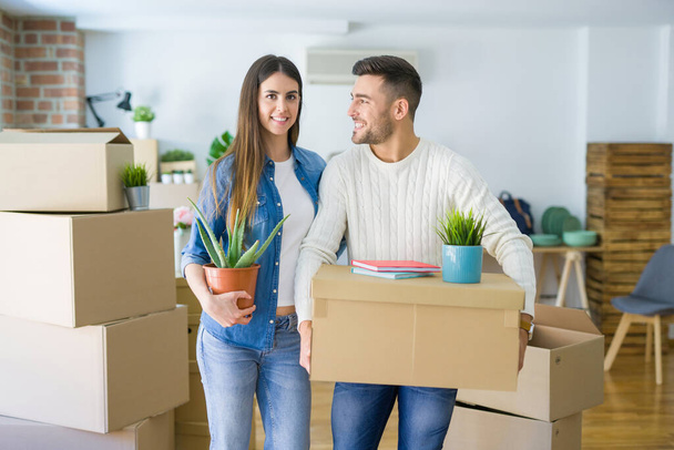 Beautiful young couple moving to a new house, smiling happy hold - Foto, imagen