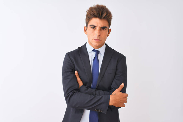 Young handsome businessman wearing suit standing over isolated white background skeptic and nervous, disapproving expression on face with crossed arms. Negative person. - Φωτογραφία, εικόνα