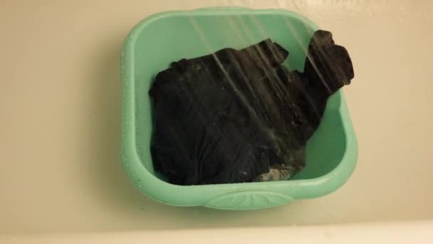 een wasbak met vuile was voor het wassen wordt gevuld met water - Video