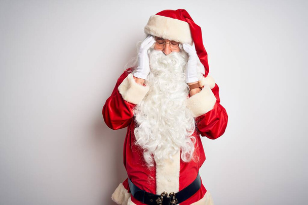 Keski-ikäinen komea mies yllään Santa puku seisoo yli eristetty valkoinen tausta käsin päänsärky, koska stressi. Migreeni
. - Valokuva, kuva