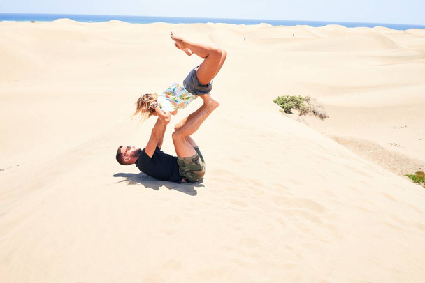 Young beautiful couple trainning acroyoga at the beach - Fotografie, Obrázek