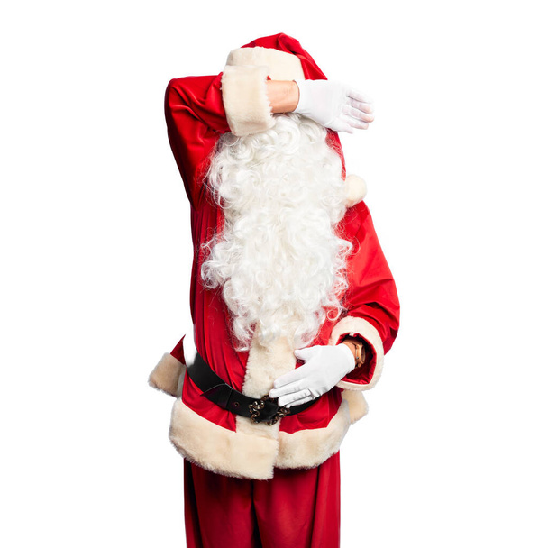 Homem bonito de meia idade vestindo traje de Papai Noel e barba de pé cobrindo os olhos com o braço sorrindo alegre e engraçado. Conceito cego
. - Foto, Imagem