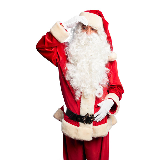Красунчик середнього віку у костюмі Санта Клауса і бороді, що стоїть стурбований і наголошений на проблемі з рукою на лобі, нервуючись і турбуючись про кризу. - Фото, зображення