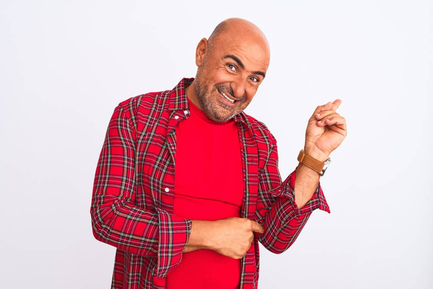 Middle age handsome man wearing casual shirt standing over isolated white background with a big smile on face, pointing with hand and finger to the side looking at the camera. - Photo, Image