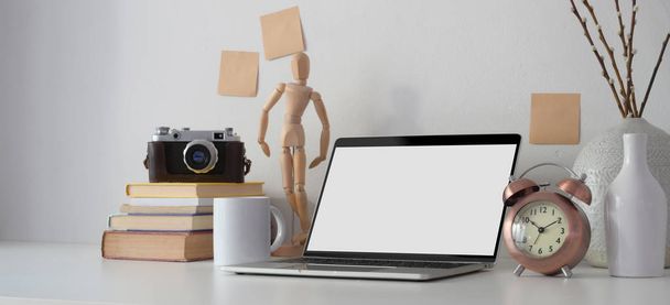 Kortárs munkahely nyitott képernyős laptop számítógép, irodai kellékek és dekorációk fehér asztalon  - Fotó, kép
