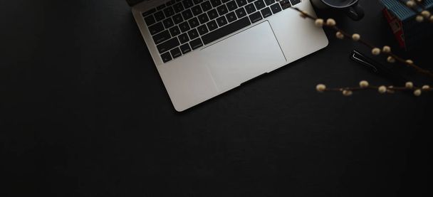 黒い革の机の上にラップトップとオフィス用品と暗い現代のワークスペースのオーバーヘッドショット  - 写真・画像