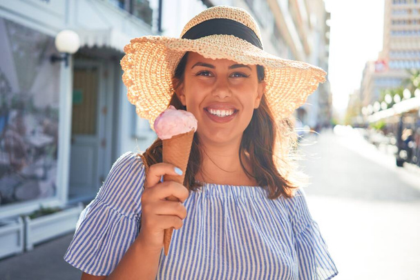 Молода вродлива жінка їсть морозиво в конусі, йдучи по вулиці Тенерифе в сонячний день літа на канікулах. - Фото, зображення