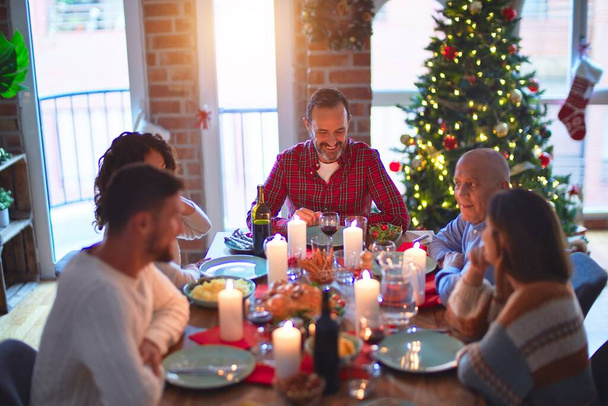 Beautiful family smiling happy and confident. Eating roasted turkey celebrating Christmas at home - Photo, Image