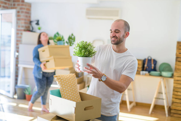 Young couple moving to new apartment, handsome man moving cardboard box - Foto, Imagen