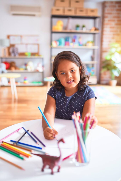 美しい幼児の女の子は幼稚園で色鉛筆を使用してかわいい絵を描く - 写真・画像