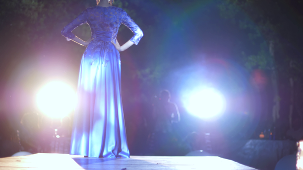 defile modello professionale in abito da sera di lusso in passerella sotto i riflettori di illuminazione
 - Filmati, video