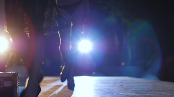 gambe sottili di modelli in scarpe nere sui tacchi alti andare in fila lungo la passerella alla sfilata di moda
 - Filmati, video