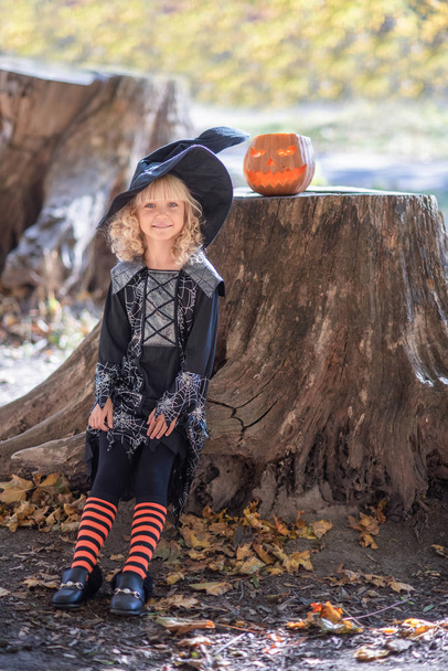 niña en traje de whitch celebrar Halloween al aire libre y divertirse
. - Foto, imagen