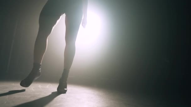 Dancers legs in dark in smoky room of nightclub. Girl dances beautifully and seductively to beat of music. Slow motion. - Filmagem, Vídeo