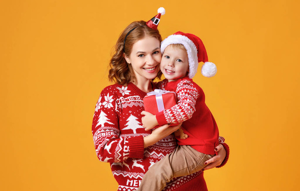 felice famiglia madre e figlio bambino con regali di Natale su giallo
 - Foto, immagini