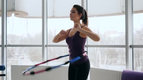 здоровое тело, стройная женщина выполняет упражнения с пластиковым кольцом против больших окон
 - Кадры, видео