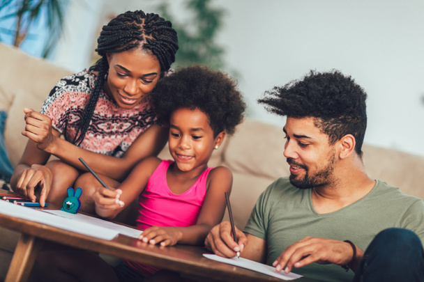 Mom and dad drawing with their daughter. African american family - Photo, Image