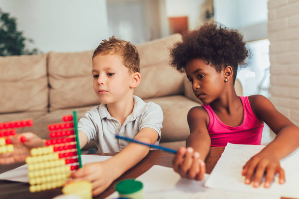 Multiraciale kinderen die thuis abacus gebruiken. - Foto, afbeelding