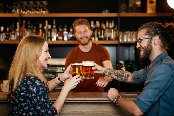 Couple caucasien debout dans le pub, griller avec de la bière et s'amuser. Vie nocturne
. - Photo, image