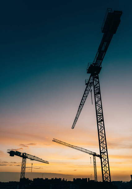 Backlit construction cranes at yard with copy space - Photo, Image