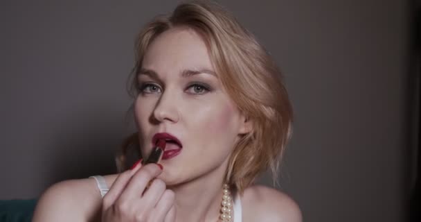 Femme blonde mettant rouge à lèvres rouge sur les lèvres
. - Séquence, vidéo