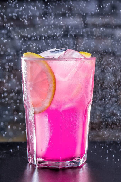 Függőleges lövés egy rózsaszín ital egy gyönyörű háttér - Fotó, kép