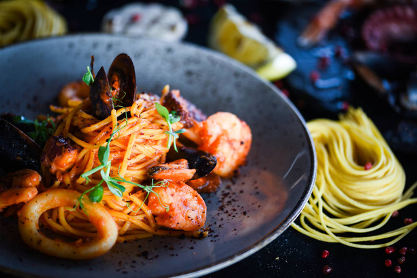 свіжа італійська паста спагетті з морепродуктами та свіжими овочами та спеціями
 - Фото, зображення