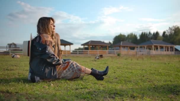Χαλαρωμένη γυναίκα που κάθεται σε στάβλο αλόγων - Πλάνα, βίντεο