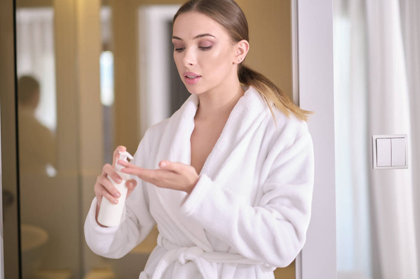 Young woman with flawless skin, applying moisturizing cream on h - Foto, Bild