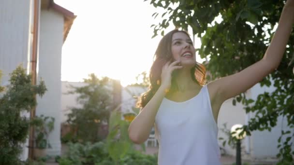 mobiele verbinding, mooi meisje praten op smartphone en genieten van de natuur in het zonlicht - Video