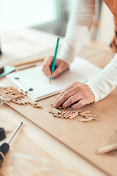 Female carpenter working with wooden dowels - Foto, imagen